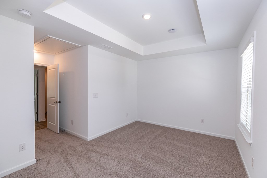 a bedroom with white walls and carpet