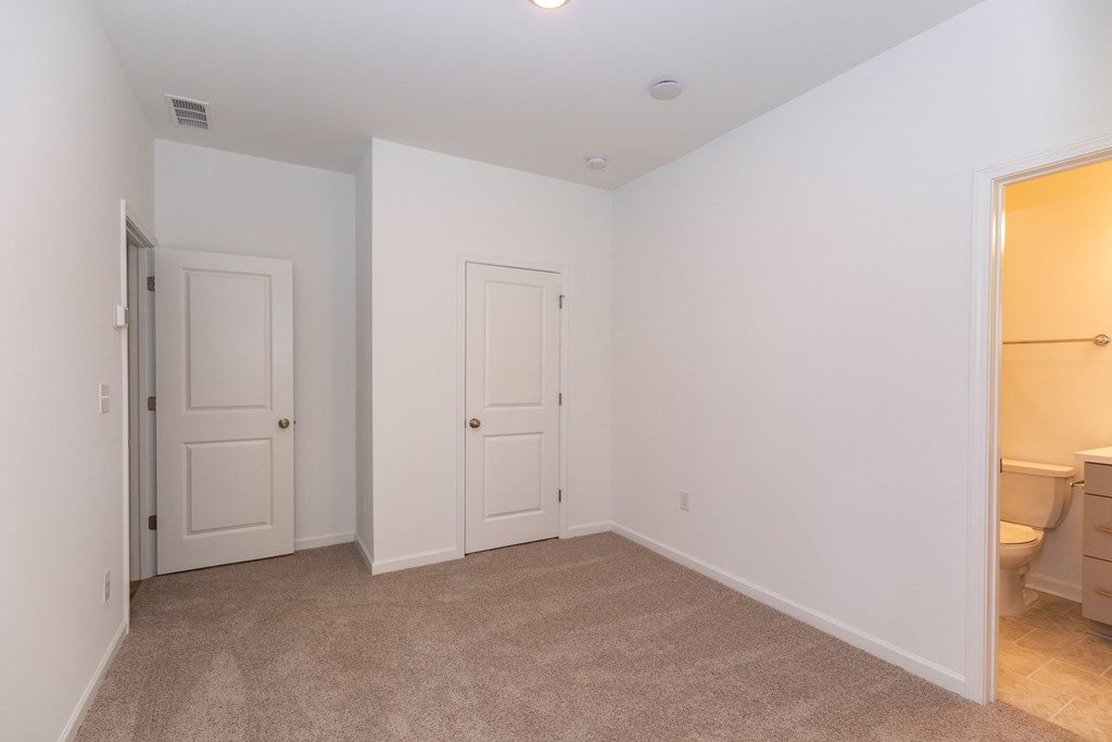 a bedroom with white walls and a carpeted floor