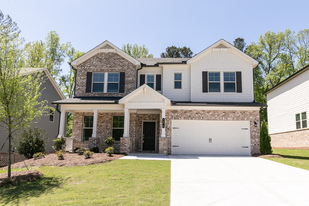 a home with a large lawn and a white garage door