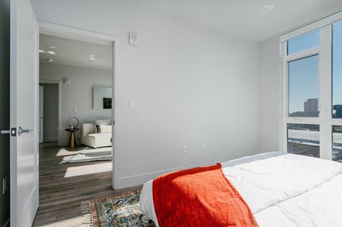 A bedroom with a large bed and a view of the city.