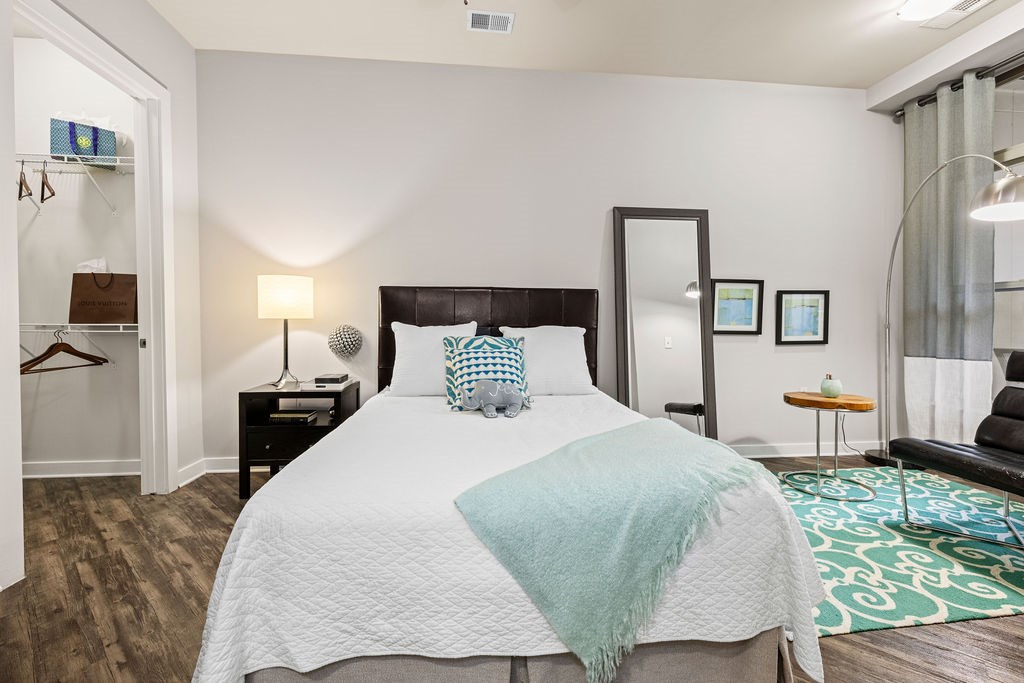 a bedroom with a bed and a mirror on the wall