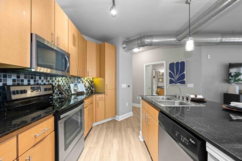 A Kitchen With Black Countertops at Mosaic South End Apartments, Charlotte, NC