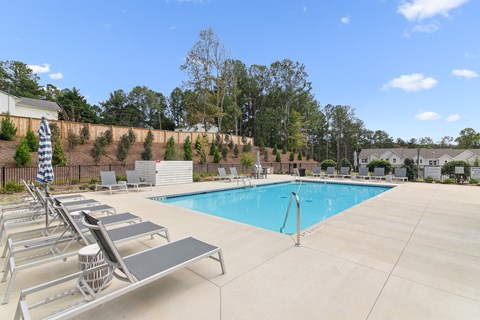 the swimming pool at our apartments with chairs and a pool