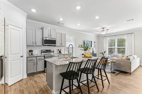 A kitchen with a table and chairs in front of a window.