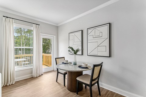 a dining room with a table and chairs and a window