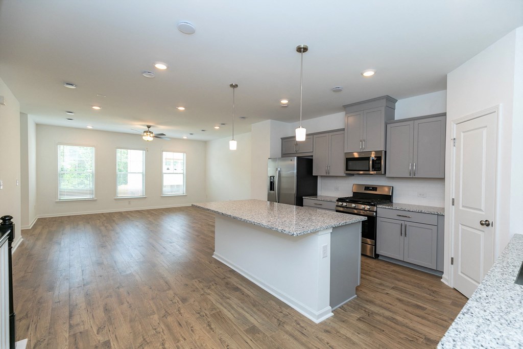 a kitchen and living room with hardwood floors and white walls