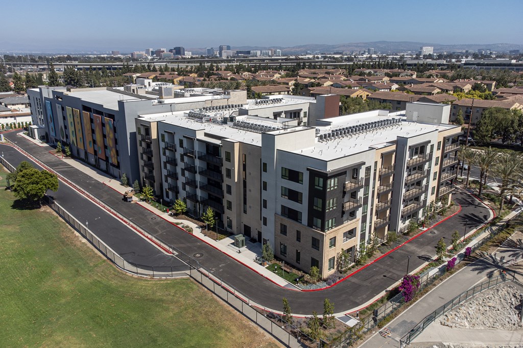 an aerial view of a large apartment complex with a city in the background