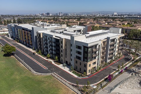 an aerial view of a large apartment complex with a city in the background