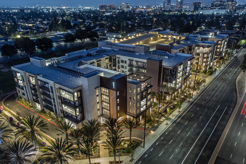 an aerial view of a large building at night with a city in the background
