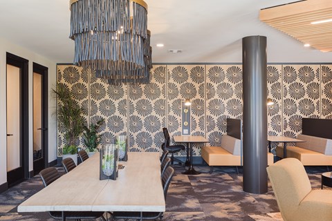 a communal area with a large table and chairs and a large chandelier