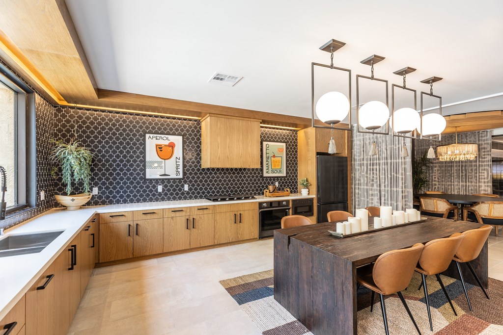 a kitchen with a long wooden table and chairs
