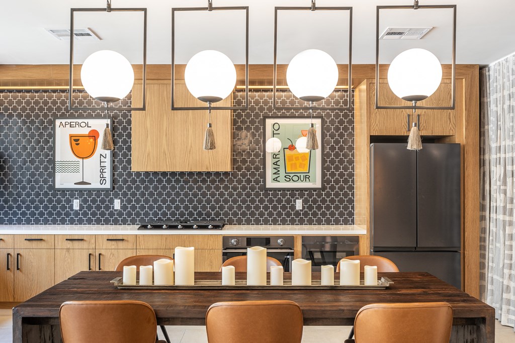 a kitchen with a long wooden table and brown chairs