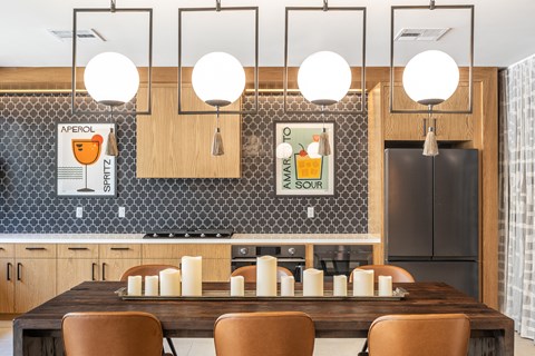 a kitchen with a long wooden table and brown chairs
