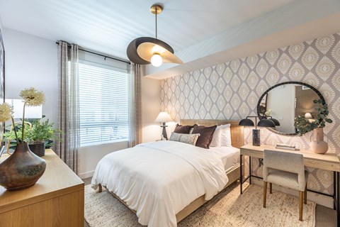 a bedroom with a bed and a desk with a mirror