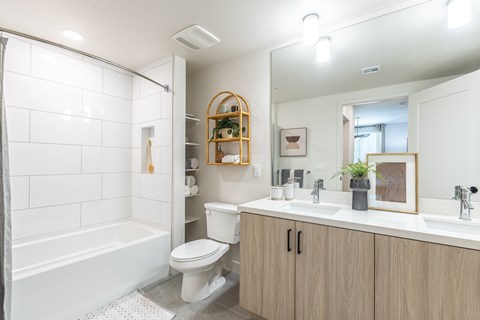 a bathroom with a white toilet next to a white bathtub and a white sink with a