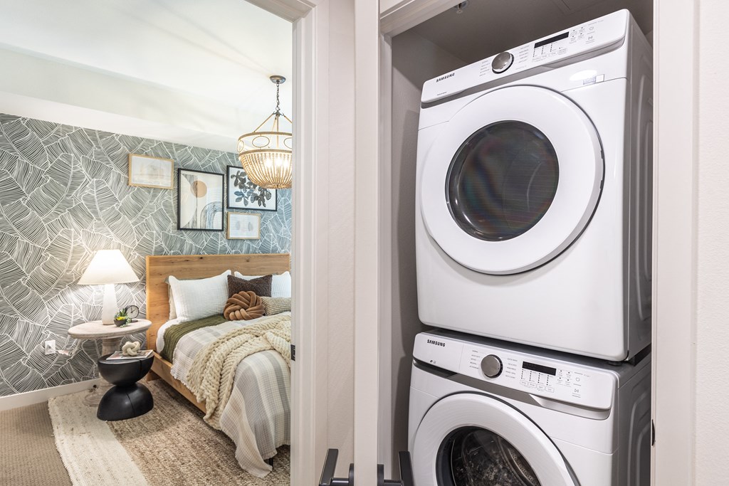 a bedroom with a washer and dryer next to a bed