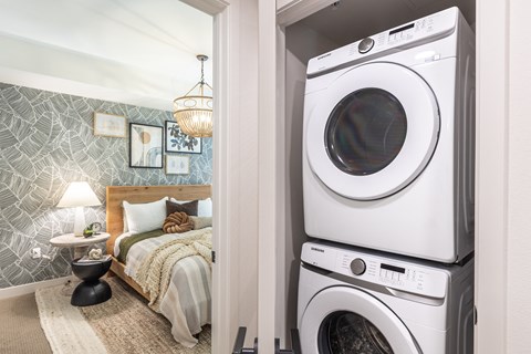 a bedroom with a washer and dryer next to a bed