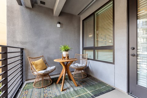 a small table and two chairs on a balcony