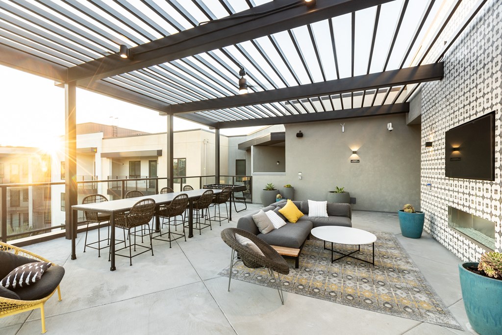 a patio with a pergola and tables and chairs