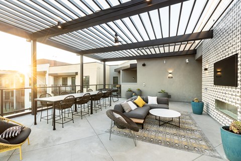 a patio with a pergola and tables and chairs