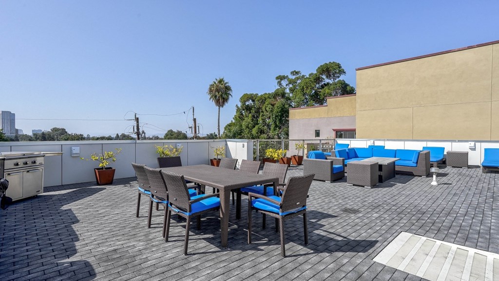 A rooftop deck at 4801 Shattuck featuring a stylish dining area and lounge space with grills.