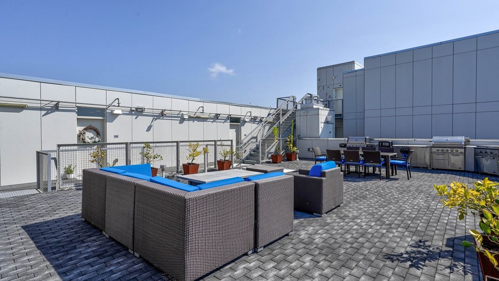 A rooftop deck at 4801 Shattuck featuring a stylish dining area and lounge space with grills.
