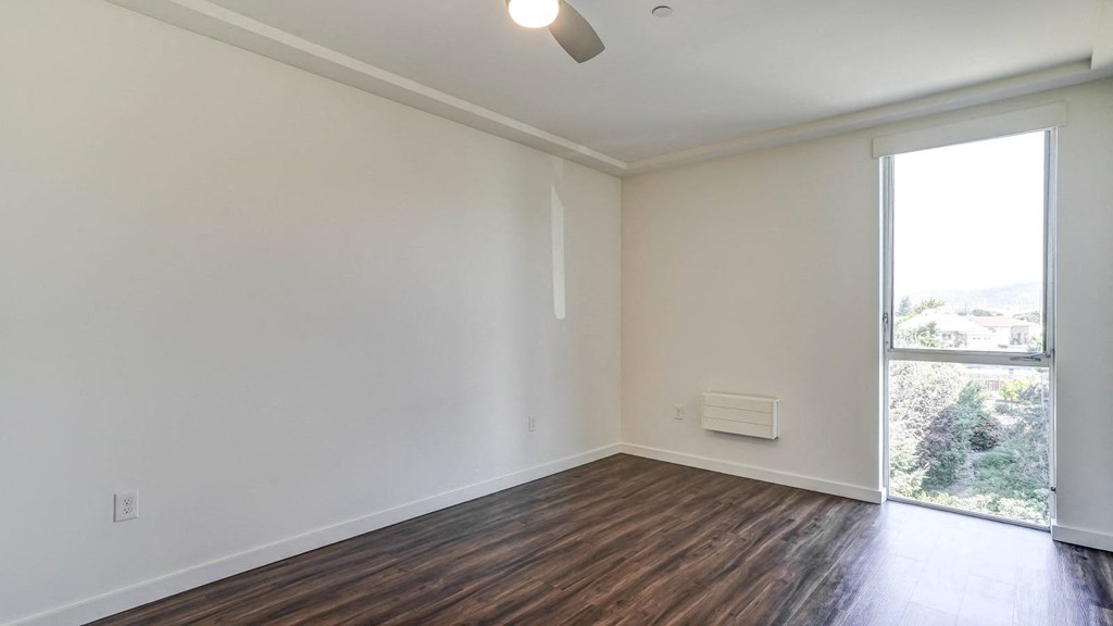 an empty living room with white walls and a window