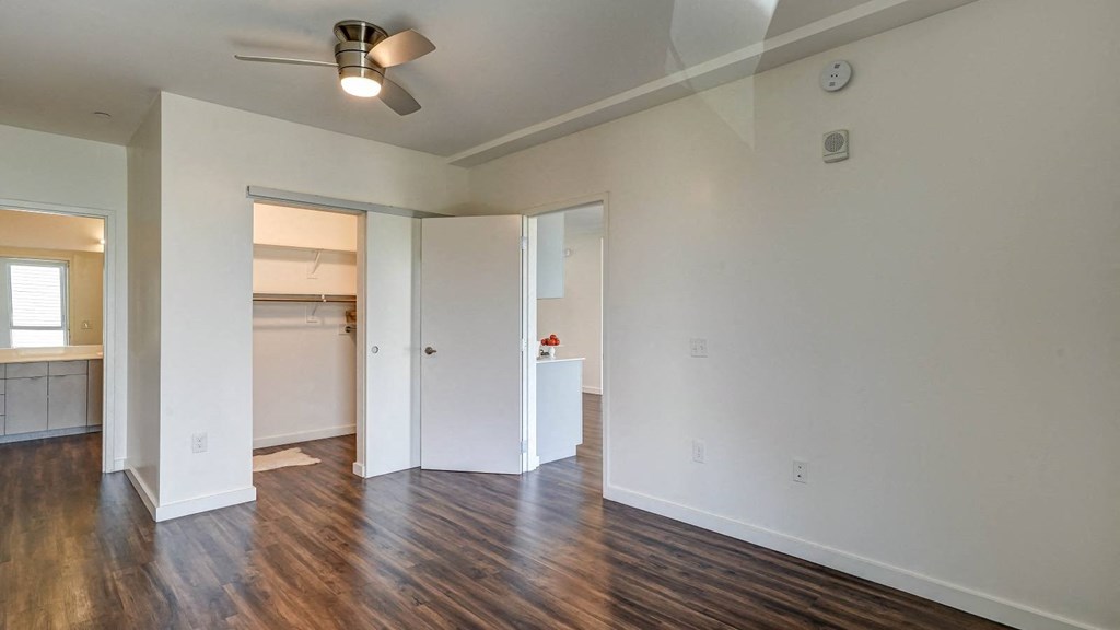 a living room with a hard wood floor and white walls