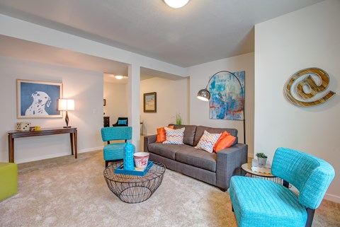 A living room with a grey couch and a blue chair.