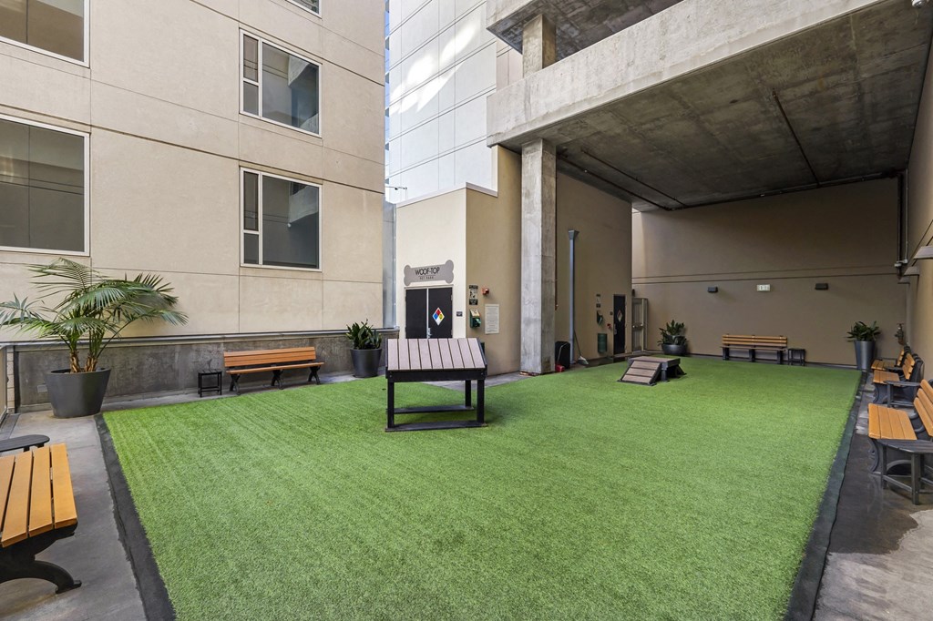 a yard with a table and benches in the middle of a building
