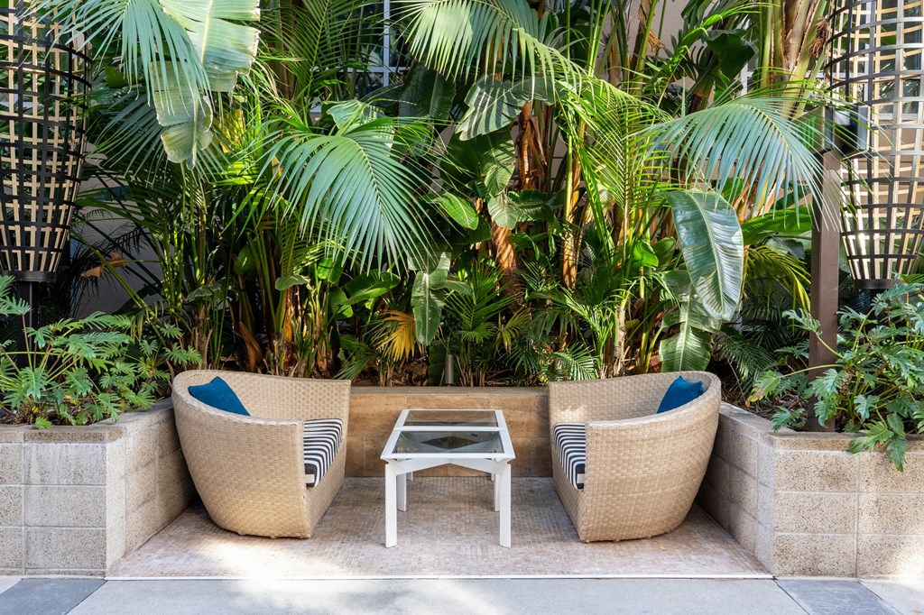 a seating area with two rattan chairs and a table
