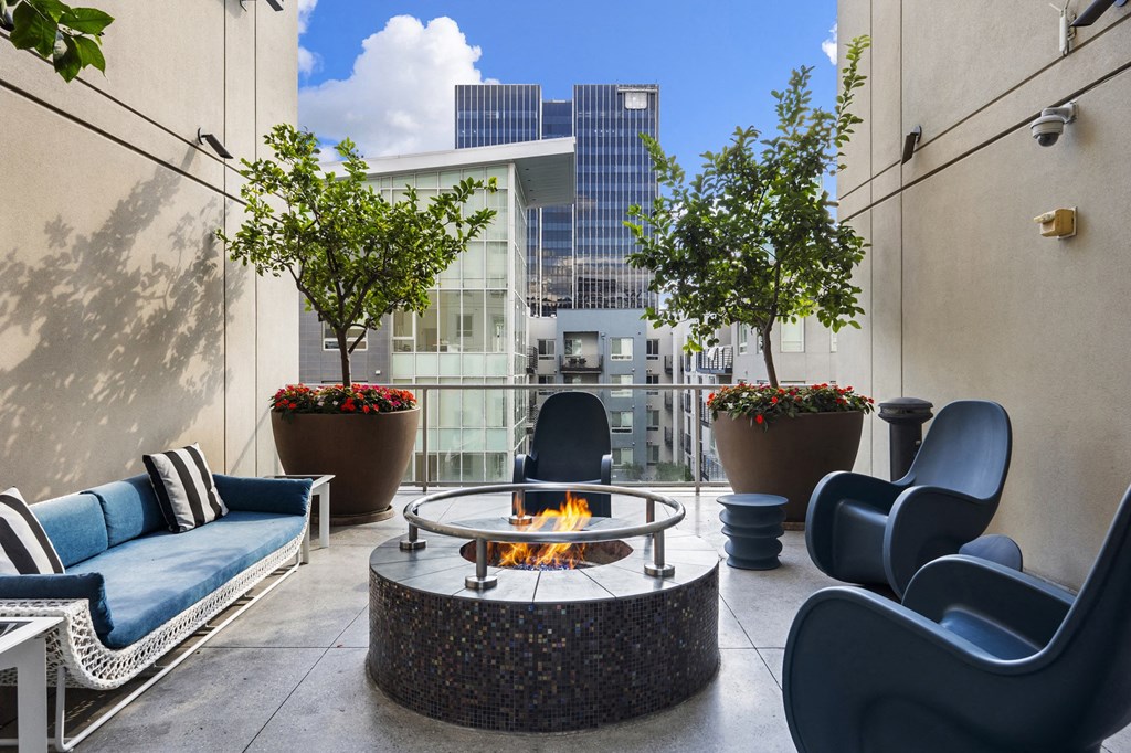 a patio with couches and chairs and a fire pit