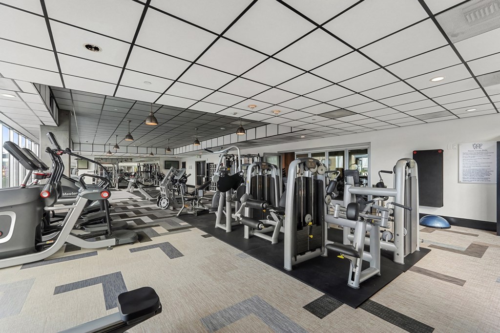 a gym with cardio equipment and weights in a building