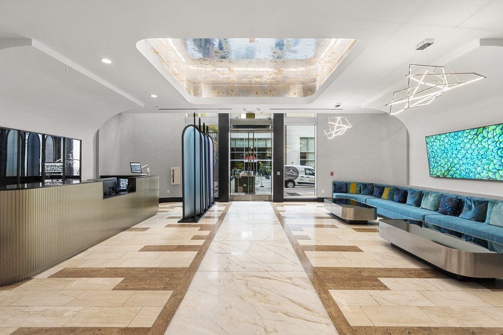 a lobby of a hotel with couches and a reception desk