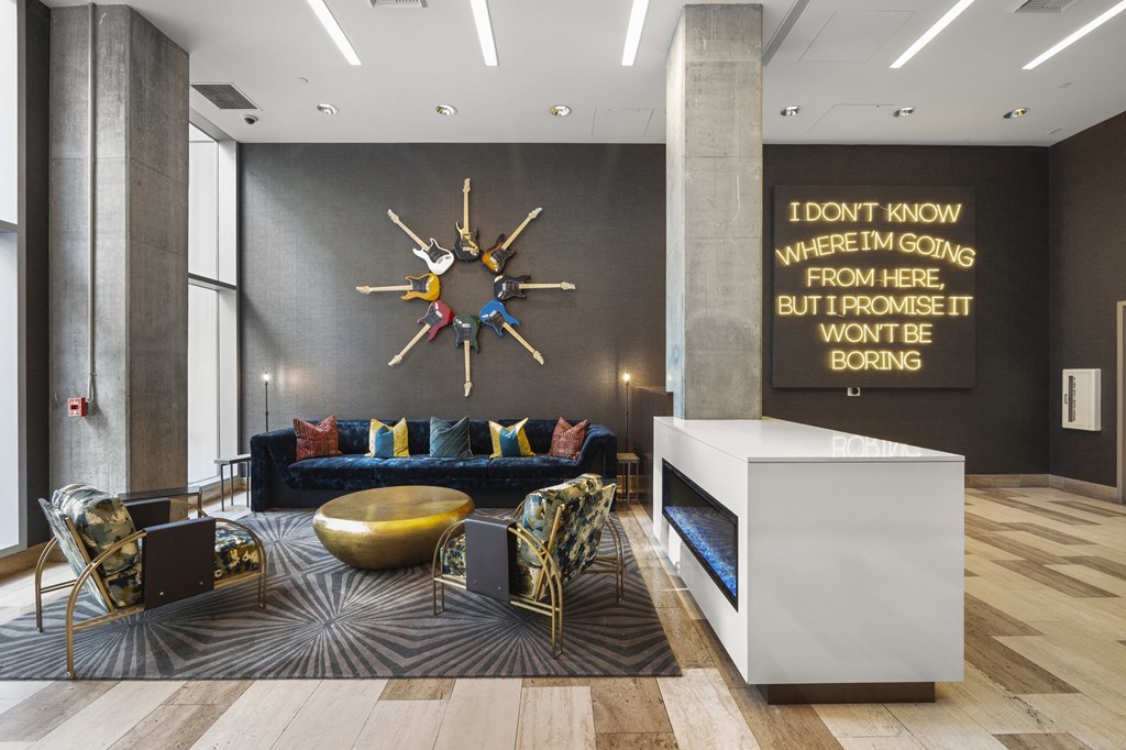 a lobby with a blue couch and a clock on the wall