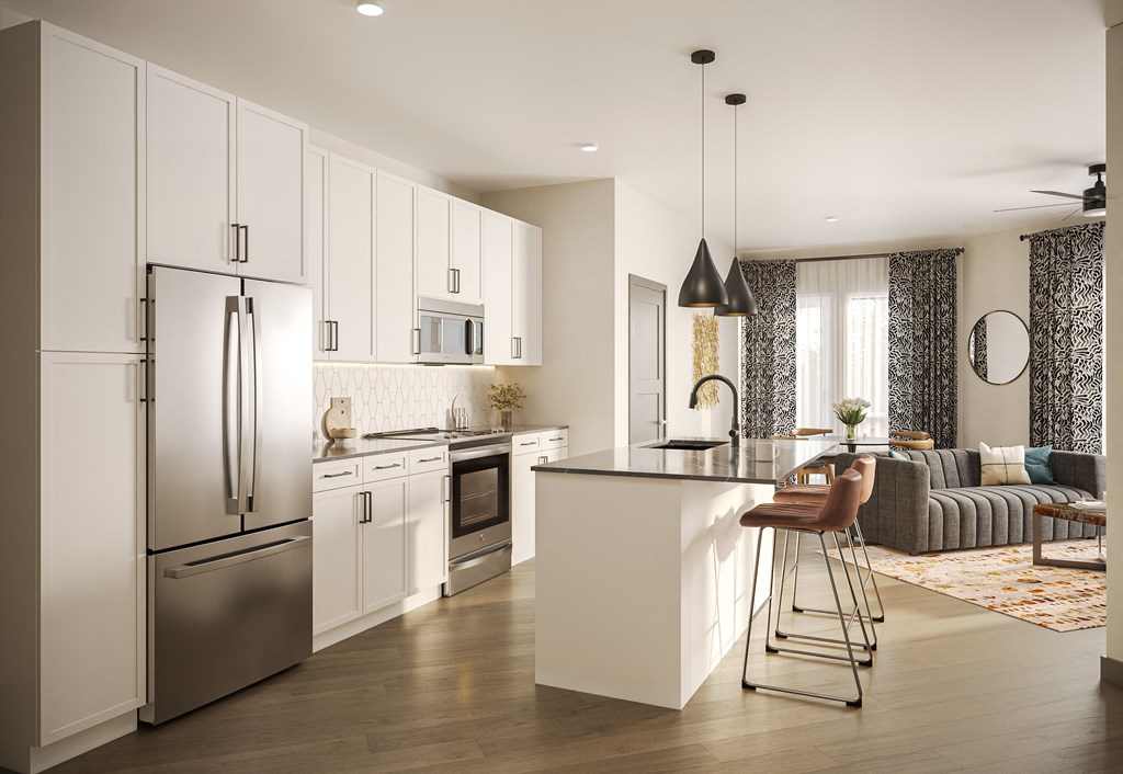 a kitchen and living room with white cabinets and stainless steel appliances