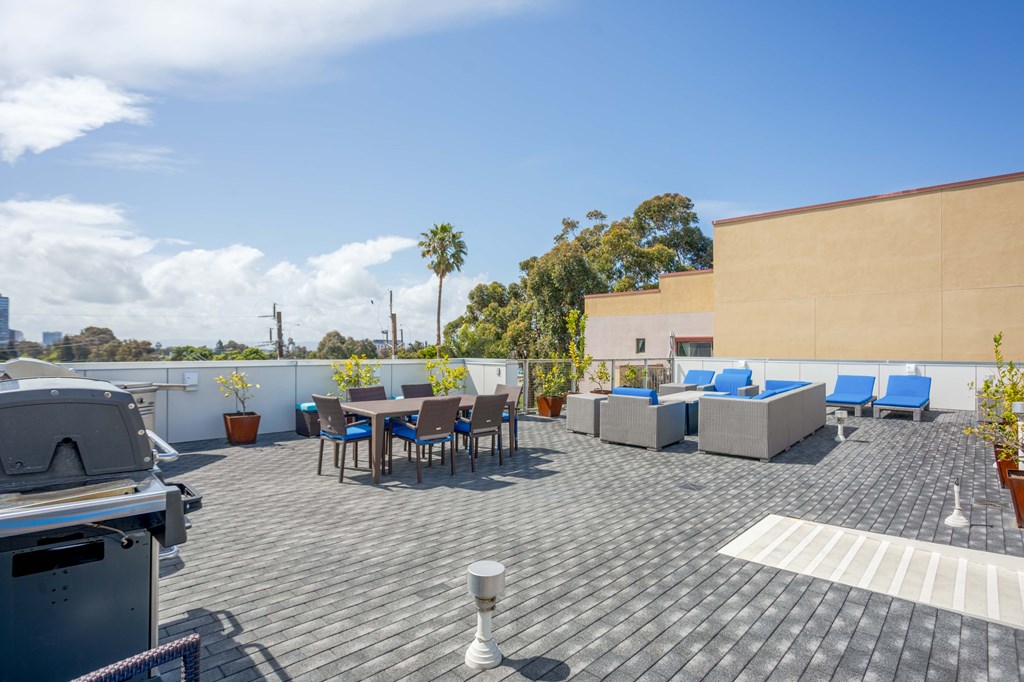 A rooftop patio with a table and chairs.