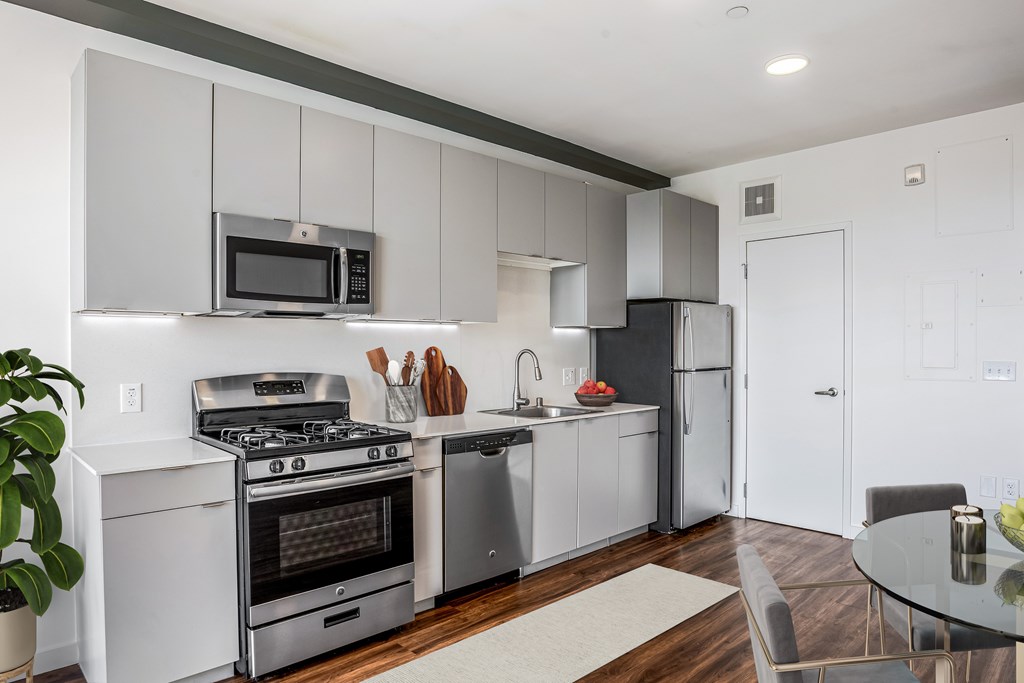 A modern kitchen with a stainless steel refrigerator, oven, and microwave.