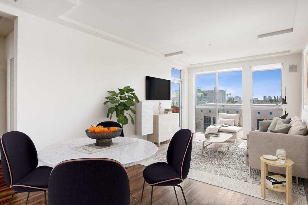 A modern dining room with a bowl of fruit on the table.