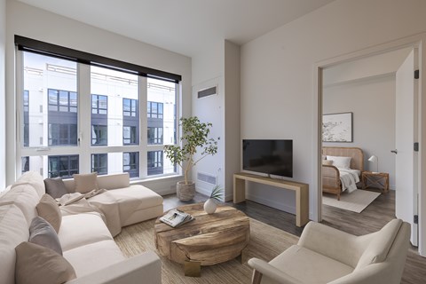 A living room with a white couch and a wooden coffee table.
