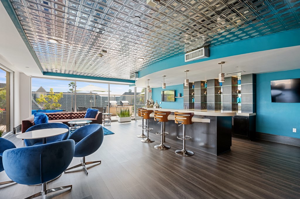 Sky lounge at 7950 West Sunset, featuring comfortable and stylish couches, along with a well-appointed bar area complete with chic bar stools