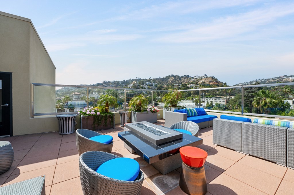 Rooftop sky lounge at 7950 West Sunset Apartments, featuring exterior chairs, sofas, and lush green plants, providing a serene and comfortable outdoor space for residents to enjoy