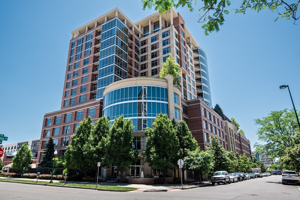 a large brick and glass building with trees in front of it