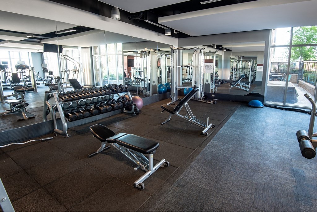 a spacious fitness center with cardio machines and weights