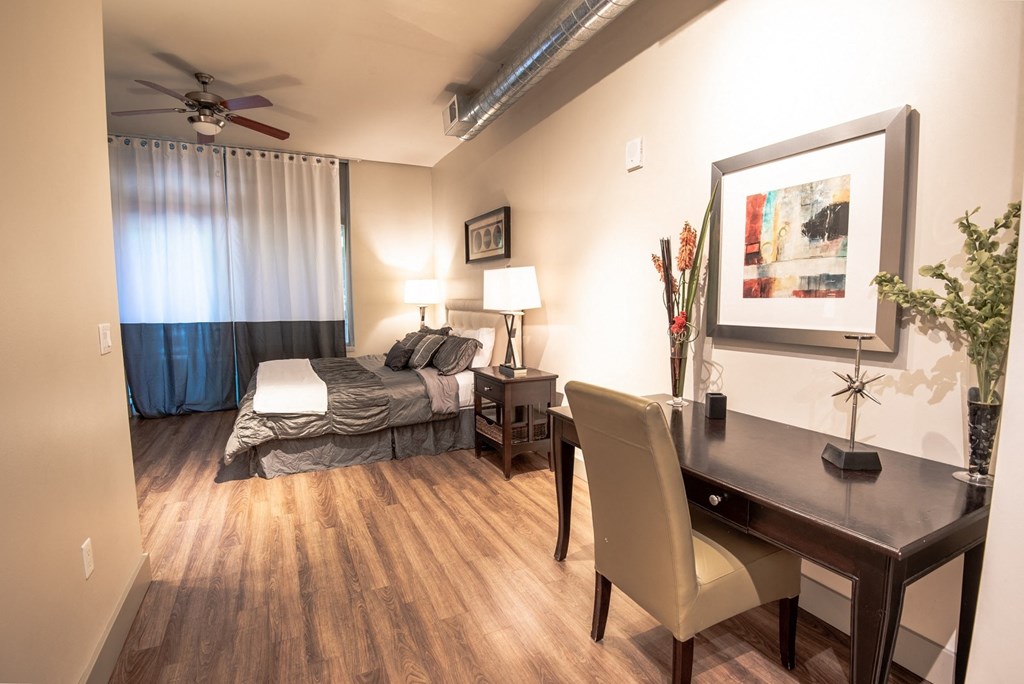 a bedroom with a bed and a desk in a room