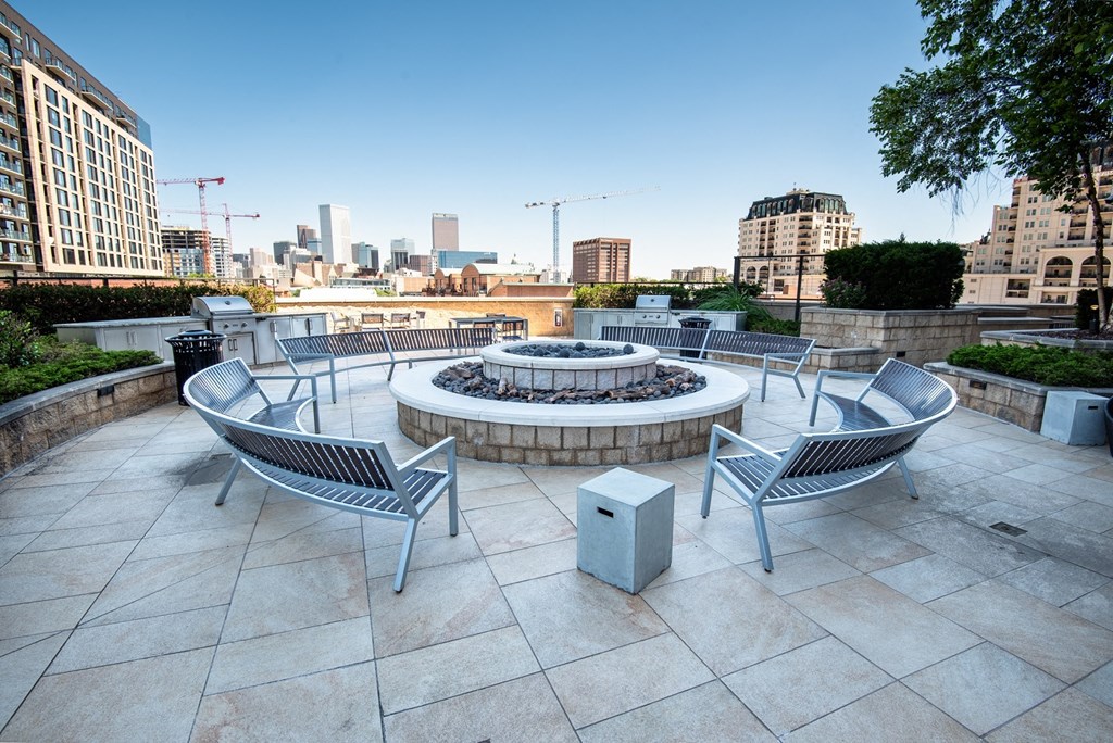an outdoor terrace with a firepit and a view of the city