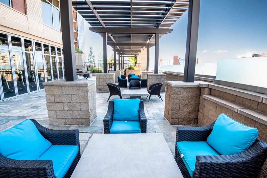 an outdoor lounge area with blue couches and chairs