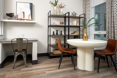 A dining area with a white table and chairs.