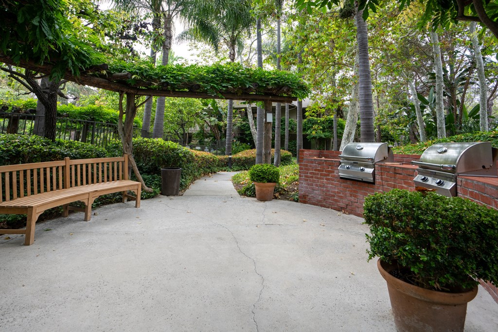 a patio with benches and barbecue grills