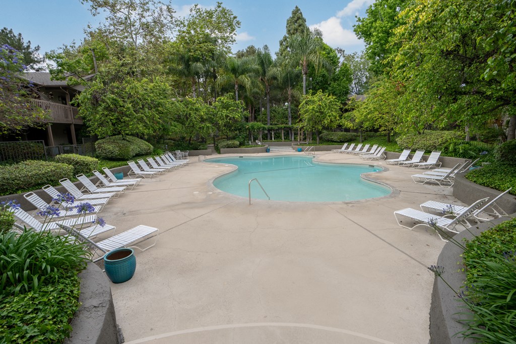 a resort style pool with white chairs around it